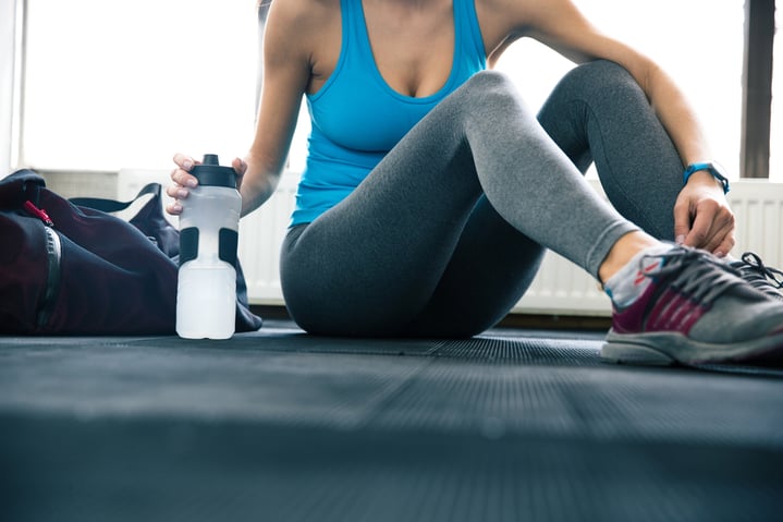 Fit woman sitting on the floor at gym